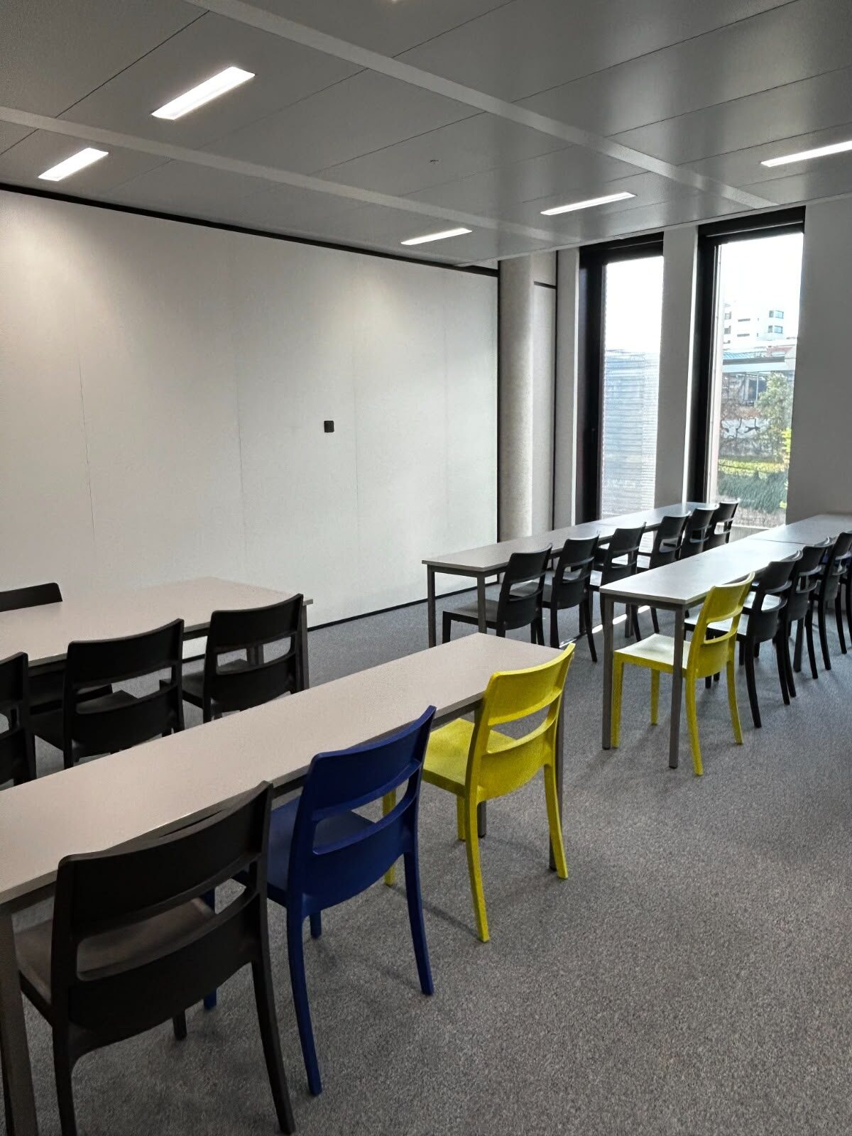 Teaching room with tables and colourful chairs